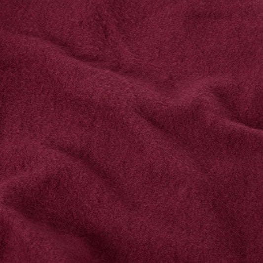 Close-up of deep red Champion Women’s Knitted Flare Pants fabric, featuring a soft, brushed texture and gentle folds.