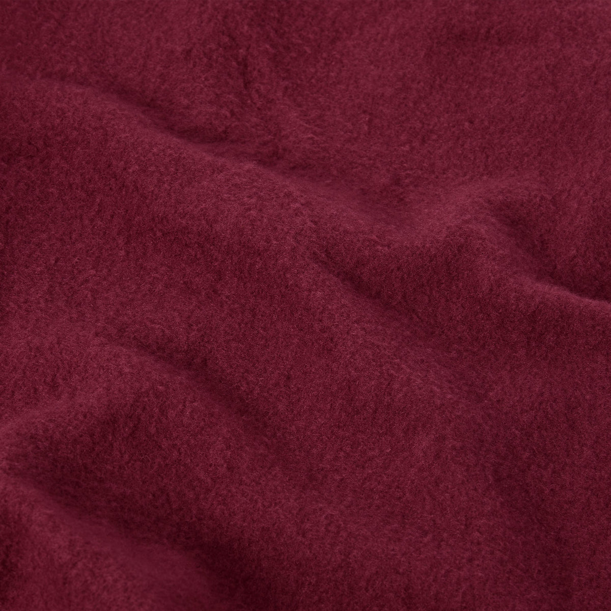 Close-up of deep red Champion Women’s Knitted Flare Pants fabric, featuring a soft, brushed texture and gentle folds.