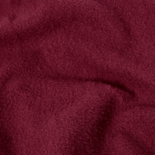 A close-up of the Champion Women’s Knitted Hooded Full Zip Sweatshirt reveals its soft, burgundy-colored knit fabric with a slightly fuzzy texture and gentle folds, evoking the plush comfort of a cozy fleece hoodie.