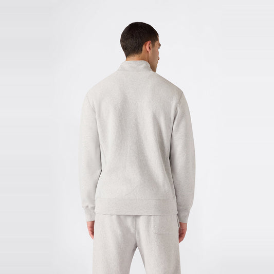 A person wearing a light gray Champion Men’s Knitted Half Zip Sweatshirt and matching sweatpants stands facing away, displaying the back of the outfit against a plain white background and highlighting this classic fleece sportswear look.