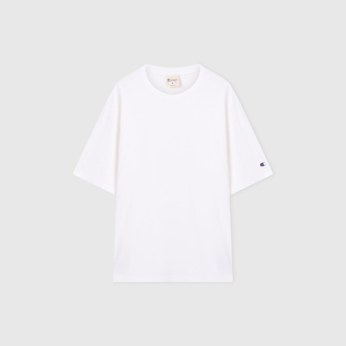 A Men’s Knitted T-Shape Tee by Champion is laid flat on a light gray background. Crafted from heavyweight cotton, this sportswear essential features a small embroidered Champion logo on the left sleeve and a visible neck tag inside the collar.