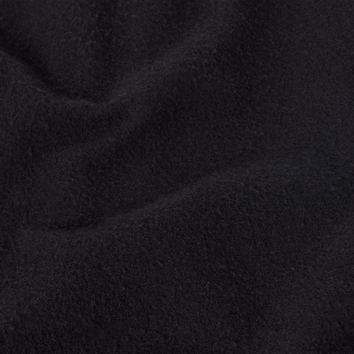 A close-up view of soft, black heavyweight fleece fabric with gentle folds and a slightly textured, fuzzy surface, reminiscent of the quality found in Champion Men’s Knitted Shorts—a staple in men’s sportswear.