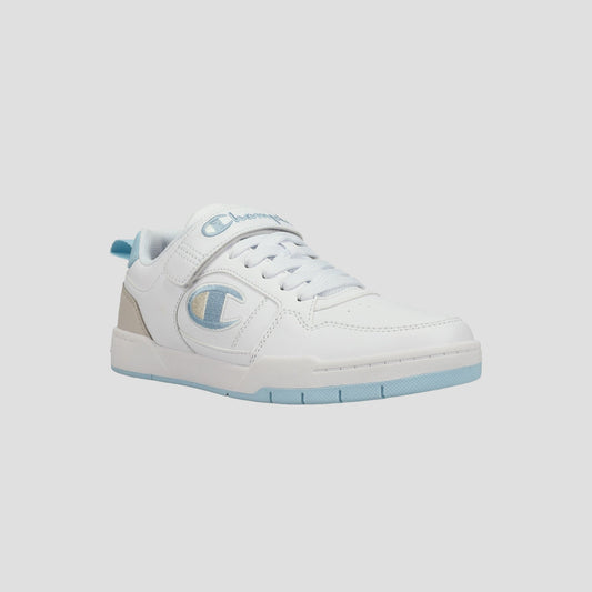 The Champion Kids' Arena Power Low sneaker features a white low-top design with light blue accents, a beige heel tab, the Champion logo on the side, white laces, and a light blue sole. Perfect for classic style on a light gray background.