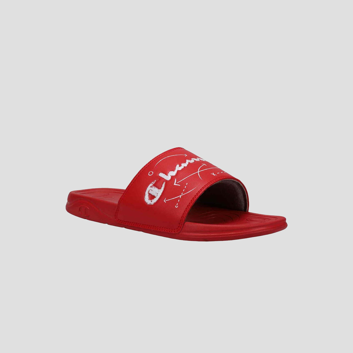 The Champion Men's Mega SFB Slide is a red sandal with a wide strap featuring white embroidered designs and text, a contoured footbed, flat sole, and open toe. Displayed on a light gray background, it’s perfect for men seeking style and comfort.