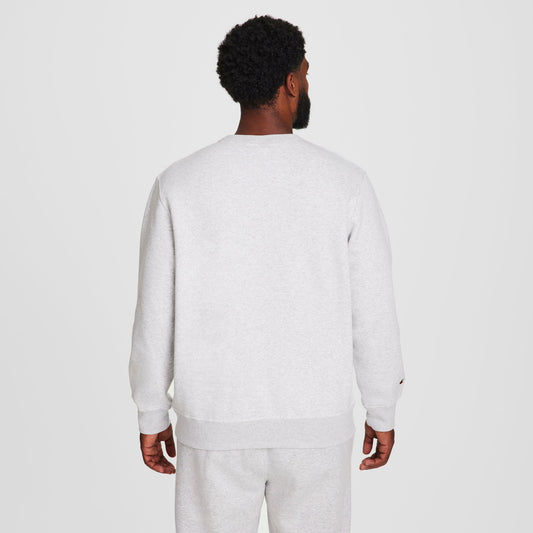 A man with short curly hair, seen from behind, wears a Champion Powerblend Crewneck Sweatshirt, C Logo - Big & Tall, along with matching sweatpants against a plain white background.