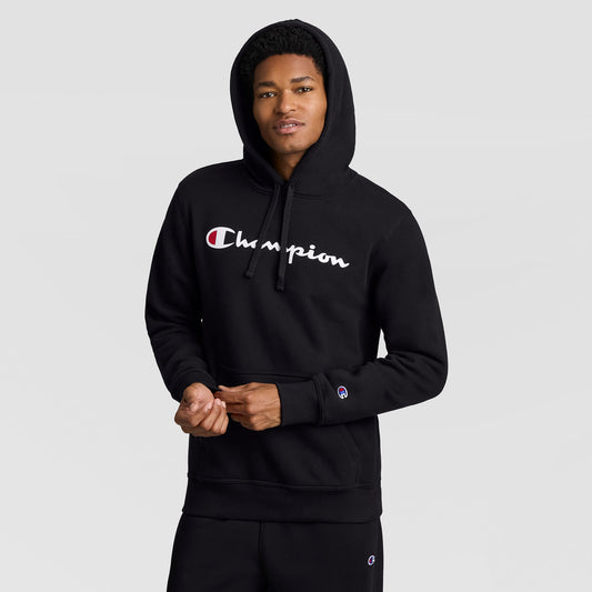 A person wears a black Champion Powerblend Hoodie, Full Script Logo, featuring the brand name in script across the chest and a small logo on the sleeve cuff.