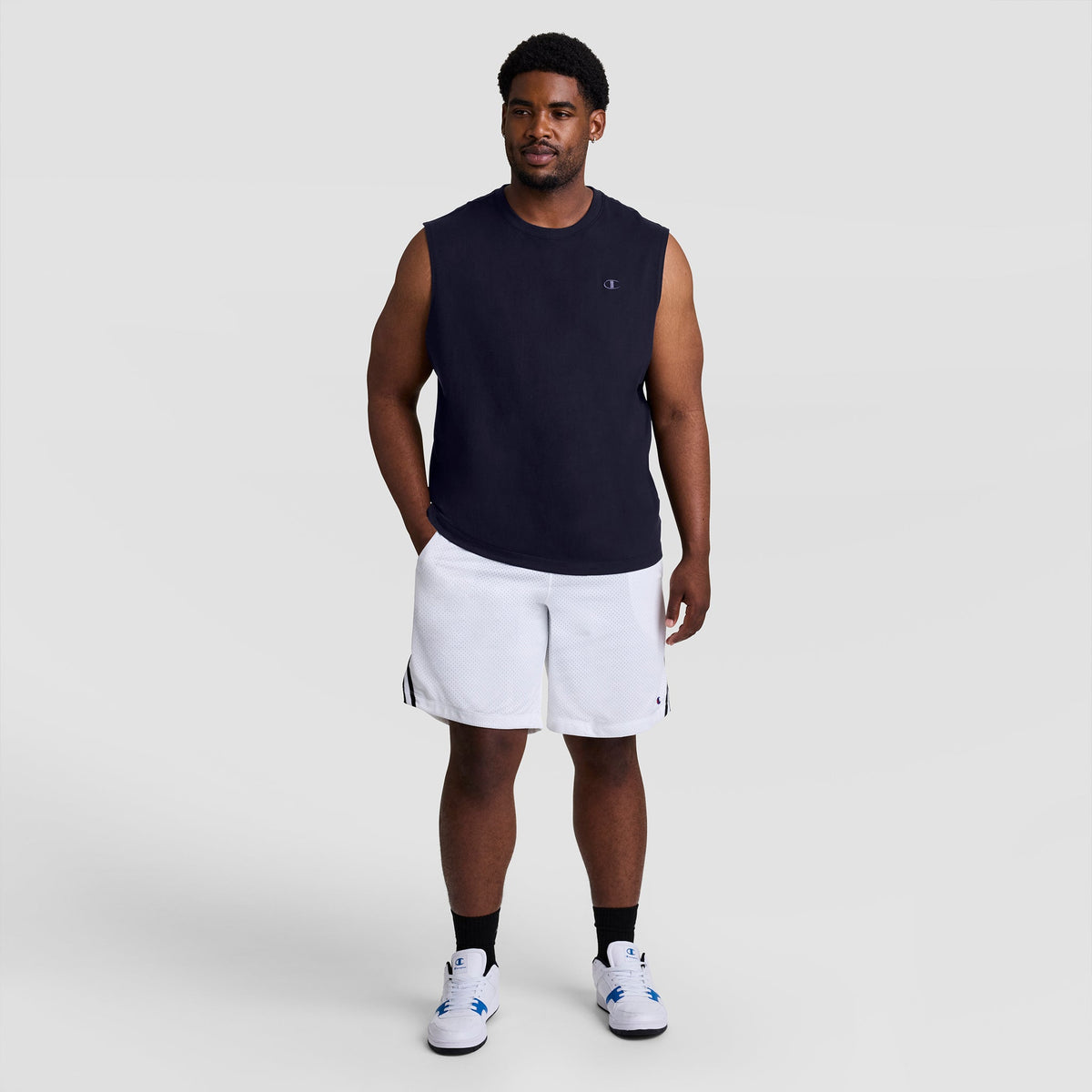 A man wearing a black Muscle Tank, C Logo - Big & Tall and white athletic shorts.