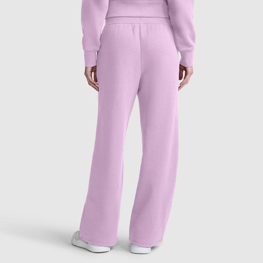 A person is shown from the back wearing Champion’s Wide Leg Fleece Sweatpants with C Logo in light purple, paired with a matching sweatshirt and white sneakers, set against a plain light gray background.