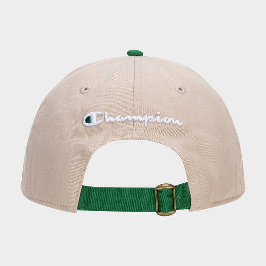 The Briggs Washed Cotton Twill Adjustable Baseball Cap by Champion is shown from the back, featuring a vintage beige look, white embroidered Champion logo, green adjustable strap with gold buckle, and a matching green top button.