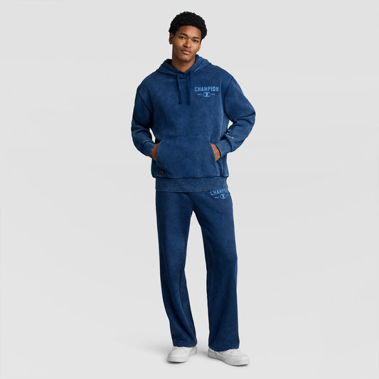 A person wearing a blue Mineral Wash Pullover Hoodie, C Patch Logo and matching sweatpants, both featuring blue logo text on the chest and thigh.