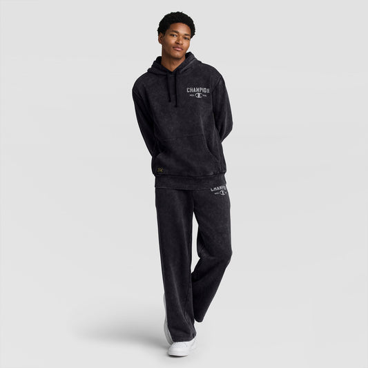 A person wearing a dark grey mineral wash hooded sweatshirt and matching Champion Mineral Wash Open Hem Pant.