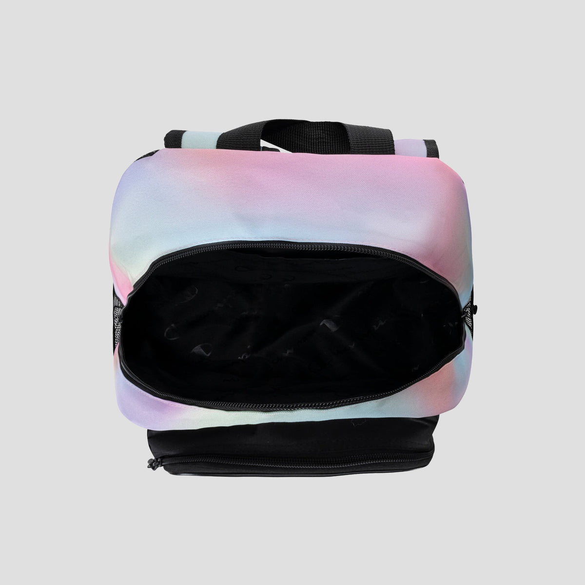 Top view of an open Champion Kids’ Mode Lunch Kit & Backpack Combo with a pastel tie-dye design and black handles, showing the empty black interior against a light gray background.