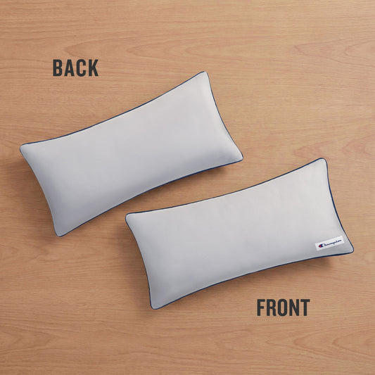 Two Champion Faux Wool Body Pillows rest on a wooden surface, labeled BACK and FRONT. The front pillow showcases a small Champion logo tag in the corner and is filled with plush polyester for superior comfort, while the back pillow remains plain.