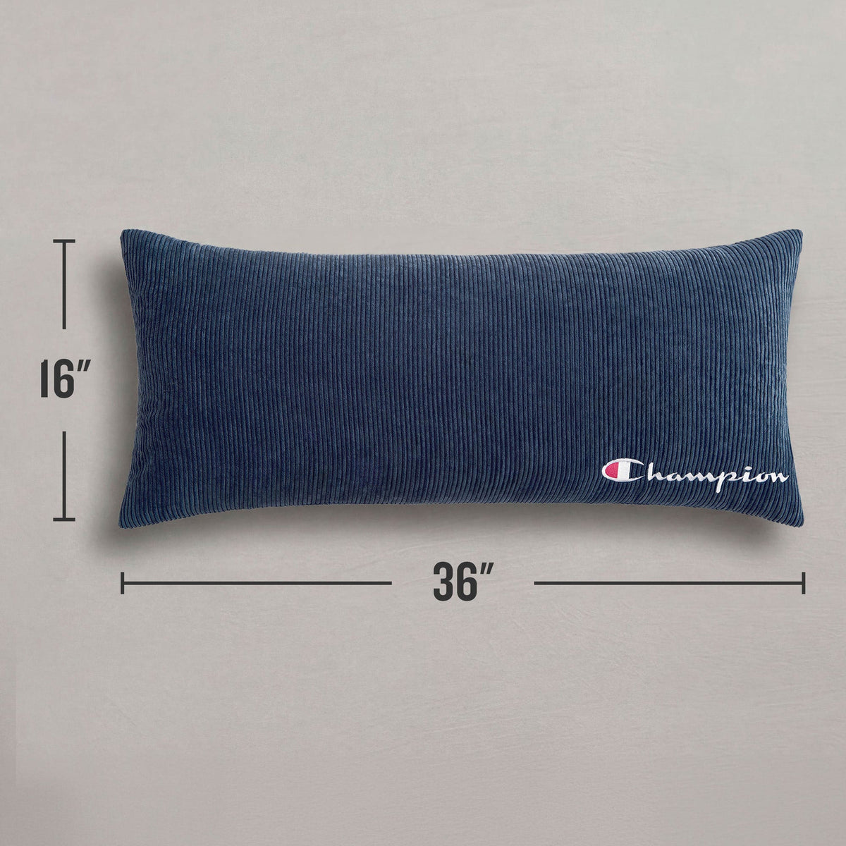 The Champion Corduroy Body Pillow from Champion, featuring a navy blue corduroy cover and the iconic logo embroidered in white on one end, measures 16 by 36 inches and adds signature comfort to any lounge area. It is displayed on a plain gray surface.