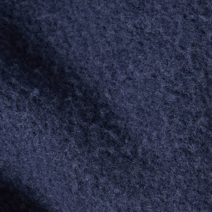Close-up of dark blue textured fabric with visible fibers and subtle shadowing, showcasing the premium look and feel of a heavyweight fleece from the Champion Women’s Knitted Hooded Sweatshirt.