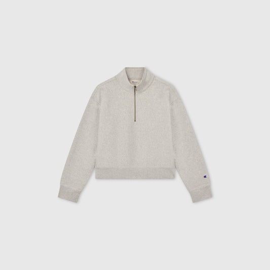 Light gray Women’s Knitted Half Zip Sweatshirt by Champion, featuring long sleeves, a cropped half-zip collar, and ribbed cuffs and hem, displayed on a plain white background—a modern essential in women’s sportswear.