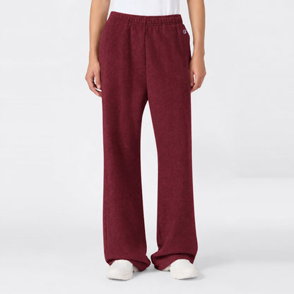 Maroon high-waisted Women’s Knitted Flare Pants by Champion with an elastic waistband and white sneakers.