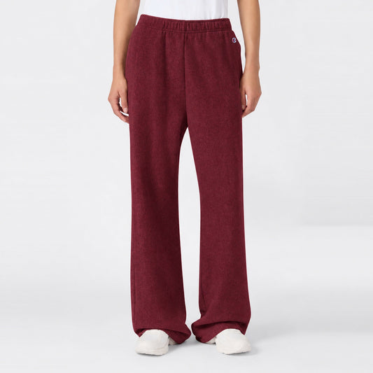 Maroon high-waisted Women’s Knitted Flare Pants by Champion with an elastic waistband and white sneakers.