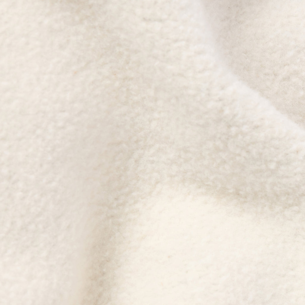 Close-up of a soft, off-white heavyweight fleece fabric with gentle folds and a slightly fuzzy appearance, showcasing the quality of Champion Women’s Knitted Flare Pants.