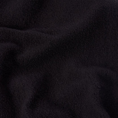 A close-up of soft, black fleece fabric, commonly found in Champion Women’s Knitted Flare Pants, highlighting its textured surface and gentle folds.