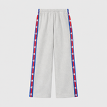 Light gray Champion Women’s Knitted Wide Leg Pants featuring a vertical stripe down each leg with a repeating logo pattern in red, white, and blue.