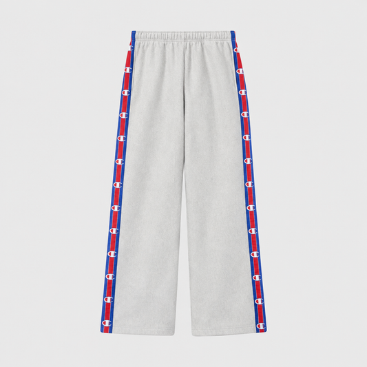 Light gray Champion Women’s Knitted Wide Leg Pants featuring a vertical stripe down each leg with a repeating logo pattern in red, white, and blue.