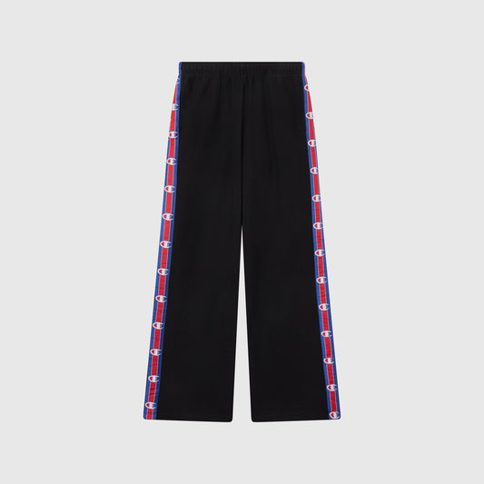 Women’s Knitted Wide Leg Pants by Champion in black, featuring blue and red striped side panels with repeated Champion logos. These pants have a relaxed fit, an elastic waistband, and are photographed against a plain light gray background.