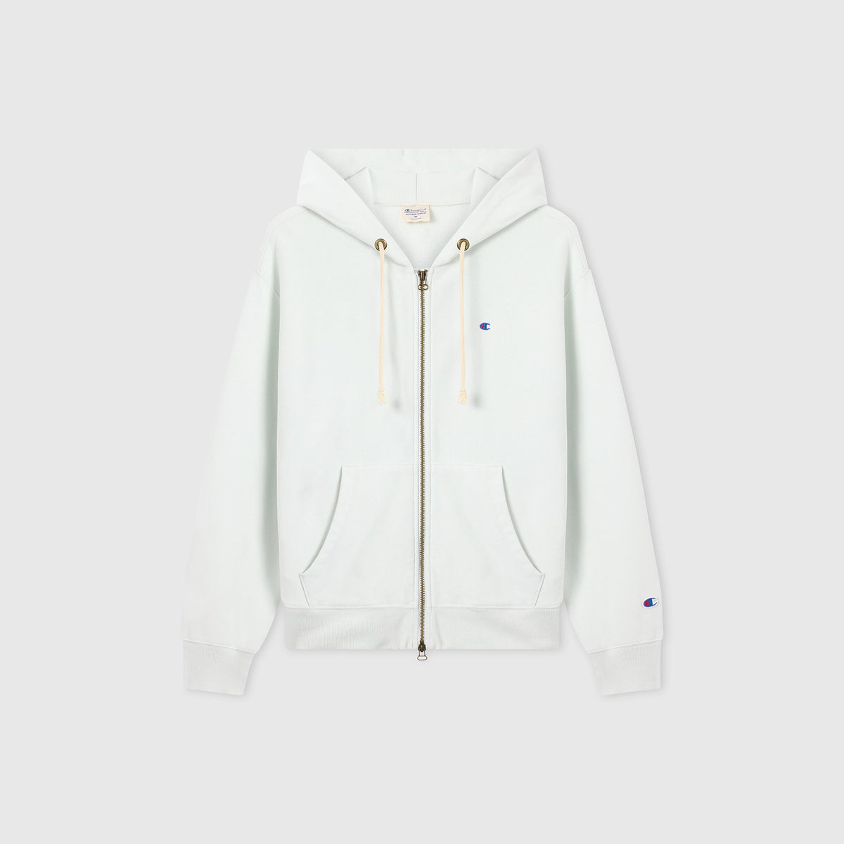The Champion Women’s Knitted Hooded Full Zip Sweatshirt is a white fleece hoodie featuring a full-length zipper, hood with drawstrings, and front pockets. It is accented with a small blue Champion logo on the left chest and sleeve and is displayed against a plain light background.