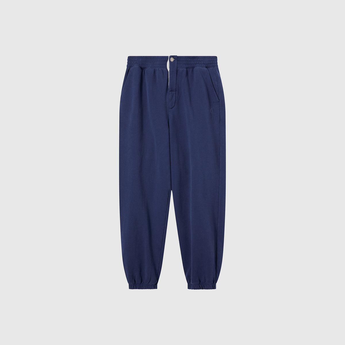 Champion Men’s Knitted Elastic Cuff Pants in navy blue are crafted from Reverse Weave fleece and feature an elastic waistband, front button and zipper, side pockets, and elastic cuffs—these men’s trousers are displayed on a light gray background.