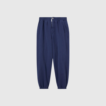 Champion Men’s Knitted Elastic Cuff Pants in navy blue are crafted from Reverse Weave fleece and feature an elastic waistband, front button and zipper, side pockets, and elastic cuffs—these men’s trousers are displayed on a light gray background.