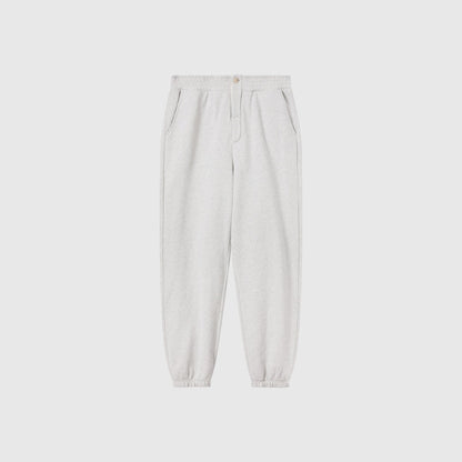Men’s Knitted Elastic Cuff Pants by Champion in light gray, crafted from heavyweight fleece. These sweatpants feature an elastic waistband and cuffs, front pockets, and a button closure. Shown against a plain white background, they offer classic Reverse Weave durability and comfort.