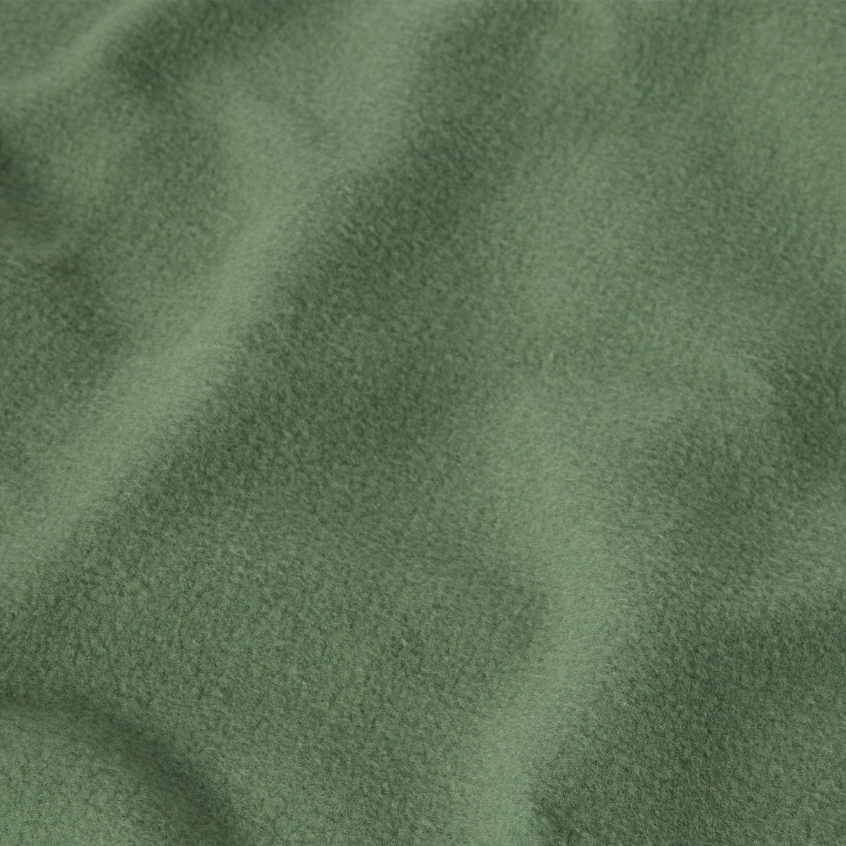 A close-up of heavyweight fleece fabric from the Champion Men’s Relaxed Fit Crewneck Sweatshirt, displaying a soft, textured surface with gentle folds and shadows.