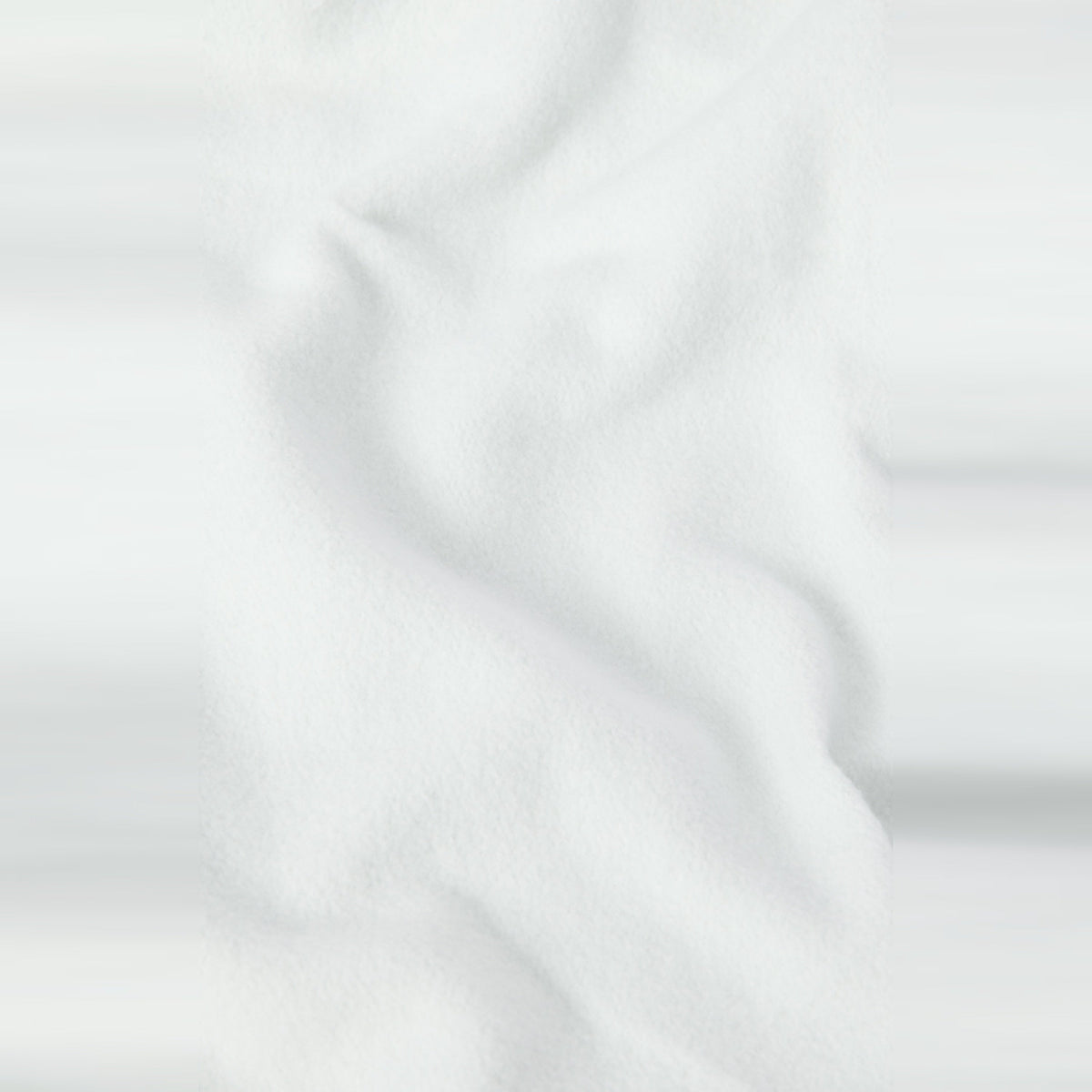 A close-up of soft, white fabric with gentle folds and subtle shadows, evoking the smooth, textured appearance of heavyweight fleece found in the Champion Men’s Knitted Hooded Sweatshirt (Embroidered Logo).