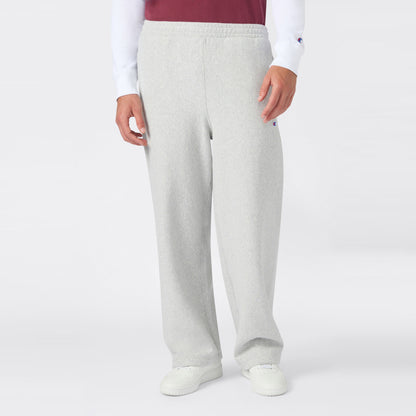 A person is shown from the waist down wearing Champion Men’s Knitted Wide Leg Pants in light gray, paired with a white long-sleeve shirt, a red vest, and white sneakers, standing against a plain white background.