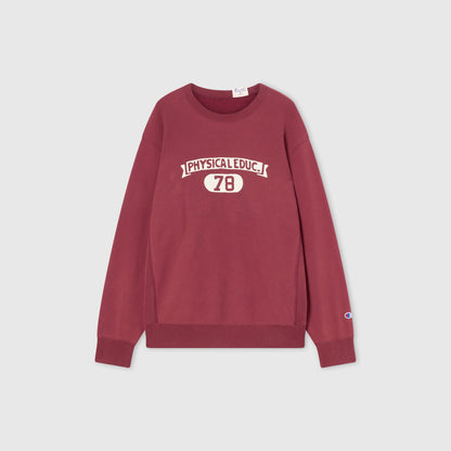 A maroon Champion Men’s Knitted Crewneck Sweatshirt (Reversible + Vintage Wash) featuring “PHYSICAL EDUC. 78” in white lettering on the front and a small Champion logo on the left sleeve, laid flat on a plain light gray background.