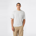 A man stands against a plain white background, wearing the Champion Men’s Knitted T-Shape Tee paired with khaki pants, one hand in his pocket and a neutral expression—perfectly embodying the effortless style of modern men’s sportswear.