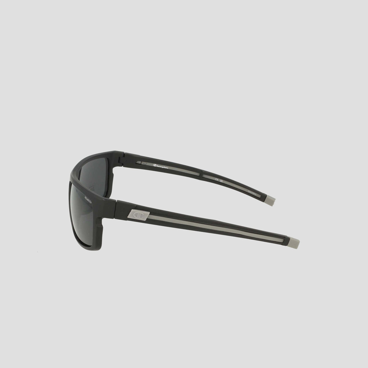 Side view of Champion Men's Polarized Wrap - Large sunglasses in black, featuring dark polarized lenses and straight, sturdy arms with a subtle silver logo near the hinges, displayed on a plain light gray background. This men's wrap frame delivers both durability and timeless style.