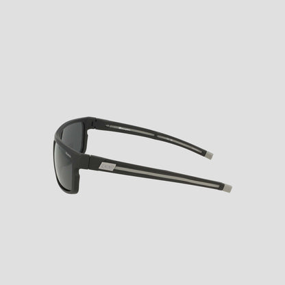 Side view of Champion Men's Polarized Wrap - Large sunglasses in black, featuring dark polarized lenses and straight, sturdy arms with a subtle silver logo near the hinges, displayed on a plain light gray background. This men's wrap frame delivers both durability and timeless style.