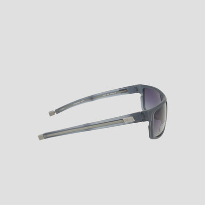 Champion Men's Polarized Wrap - Large sunglasses in gray feature a sustainable, bio-based rectangular frame with a distinctive silver accent on the left temple. Displayed from the side against a plain white background, these sunglasses offer polarized lenses with a subtle purple tint for enhanced style and functionality.