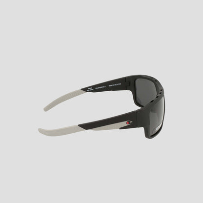 Champion Men's Polarized Grilamid Flex Grip Tip - Large sunglasses feature a sporty black and white design with dark polarized lenses. A small red and white Champion logo accents the arm, while the inside of the arm is finished in white and includes detailed model and lens information. Crafted for ultra-lightweight comfort, these sunglasses are ideal for all-day wear.