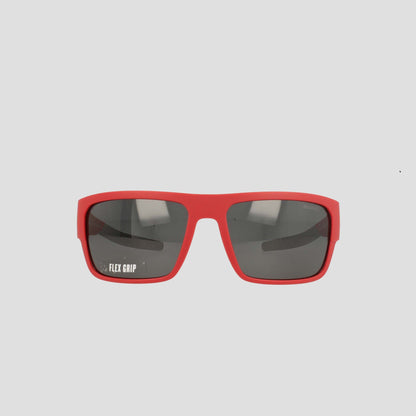 Champion Men's Polarized Grilamid Flex Grip Tip - Large sunglasses are displayed facing forward on a white background. These red rectangular sunglasses feature dark polarized lenses, with "FLEX GRIP" printed in white on the left lens. Designed by Champion for lightweight comfort, they're perfect for all-day wear.