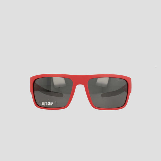 Champion Men's Polarized Grilamid Flex Grip Tip - Large sunglasses are displayed facing forward on a white background. These red rectangular sunglasses feature dark polarized lenses, with "FLEX GRIP" printed in white on the left lens. Designed by Champion for lightweight comfort, they're perfect for all-day wear.