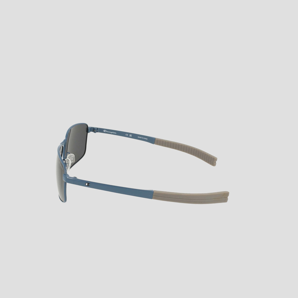 Experience the Champion Men’s Polarized Stainless ST-Shirtl Flex Grip Tip sunglasses—showcased from a side angle against a plain light background. This pair features a sleek blue frame with brown flex grip tips and polarized lenses for enhanced clarity, making them perfect for active lifestyles.