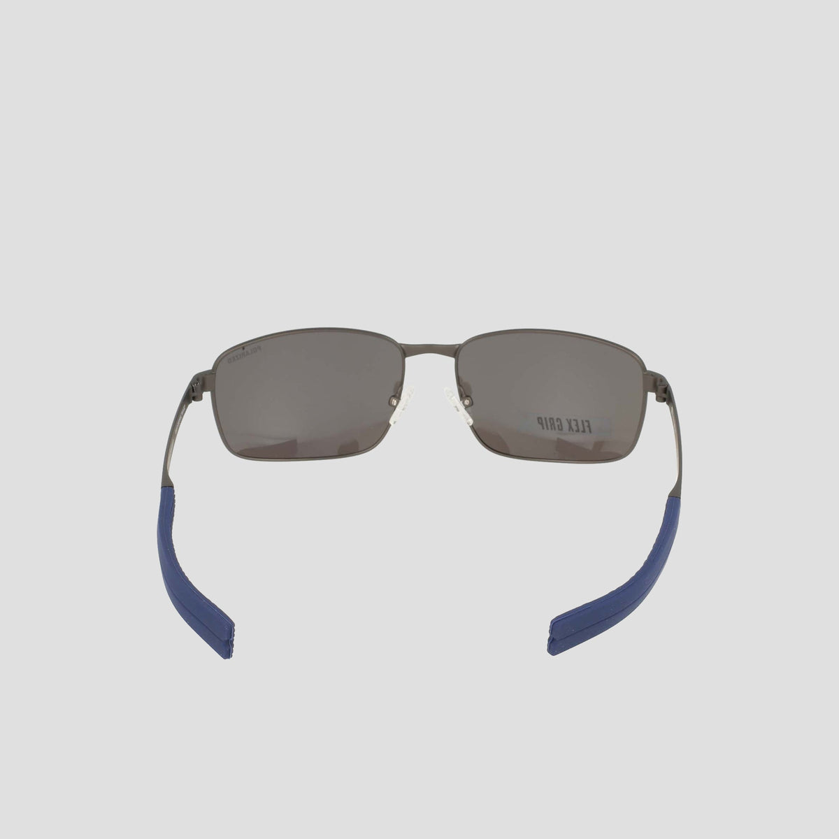 Men’s Polarized Stainless ST-Shirtl Flex Grip Tip sunglasses by Champion, featuring a rectangular design with dark polarized lenses, silver metal frames, and blue grip ear tips. Shown from the back to highlight the inside of the arms and a partial Champion logo on the right lens—an ideal choice for active lifestyles.