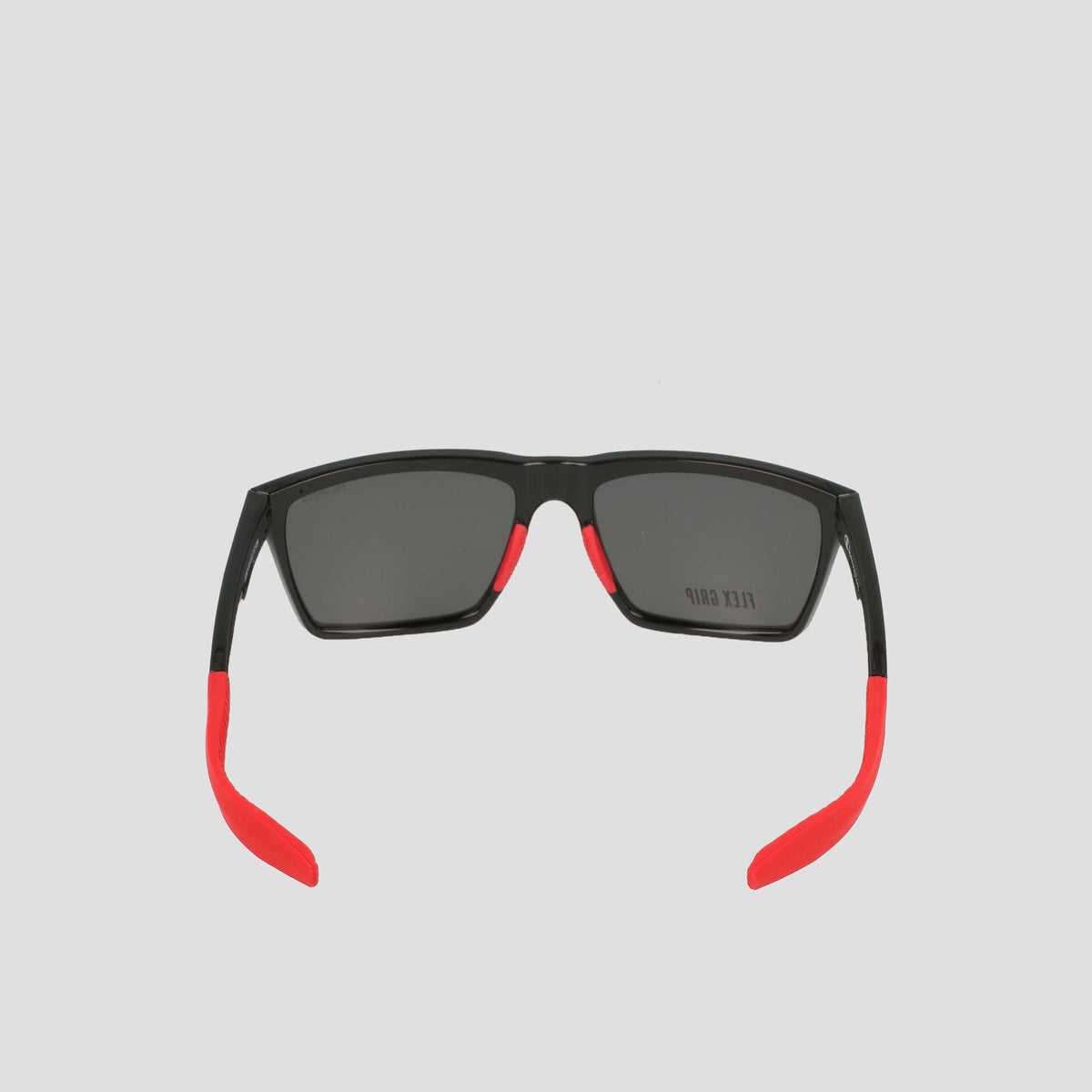 Men's Polarized Grilamid Flex Grip Tip - Medium sunglasses by Champion, shown from the back. Featuring a sleek black frame with rectangular dark lenses, these shades stand out with bright red temple tips and accents along the arms for a bold contrast. Crafted from lightweight TR90 Grilamid, this RX-able frame is designed for comfortable everyday wear. Set against a plain light gray background.