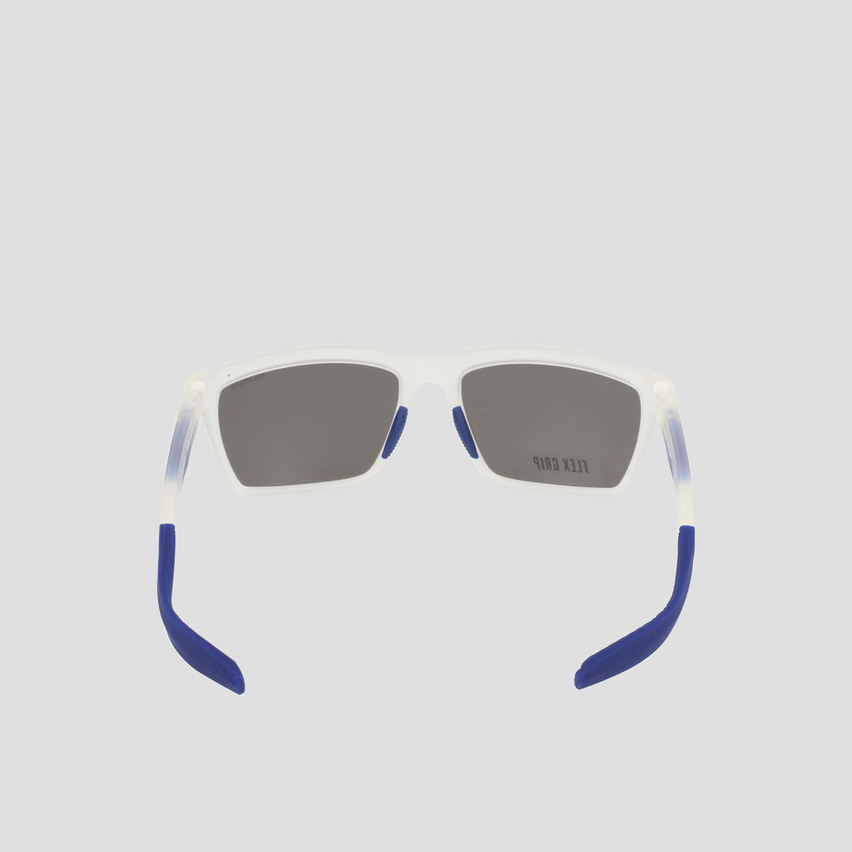 A pair of Champion Men's Polarized Grilamid Flex Grip Tip sunglasses in medium size, featuring rectangular translucent white RX-able TR90 frames with dark lenses and blue-tipped arms, is shown from the back against a plain light gray background.