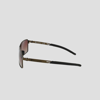 Side view of Champion Men's Polarized Stainless ST-Shirtl Comfort Fit sunglasses with brown-tinted polarized lenses, thin stainless steel frame, and black ear tips. Brand logo appears on the temple against a plain light grey background.