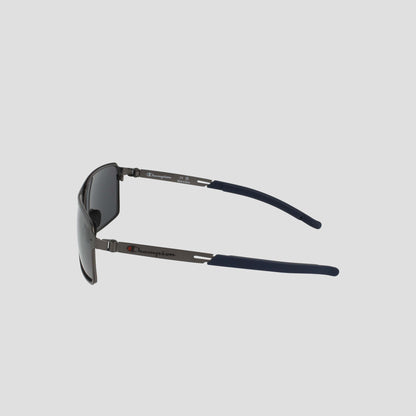 Side view of Champion Men's Polarized Stainless ST-Shirtl Comfort Fit sunglasses featuring dark tinted polarized lenses, navy blue earpieces, and a lightweight stainless steel frame with the Champion logo on the temple arms.