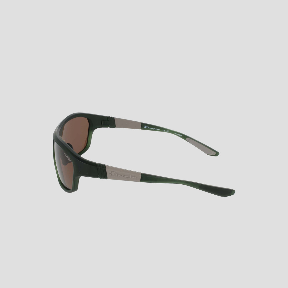 Side view of a pair of Champion Men's Polarized Comfort Fit - Large sunglasses in black and brown, with curved arms set against a plain light gray background. The TR90 frame showcases a small rectangular logo detail on the side, while adjustable rubber tips provide a secure and comfortable fit.
