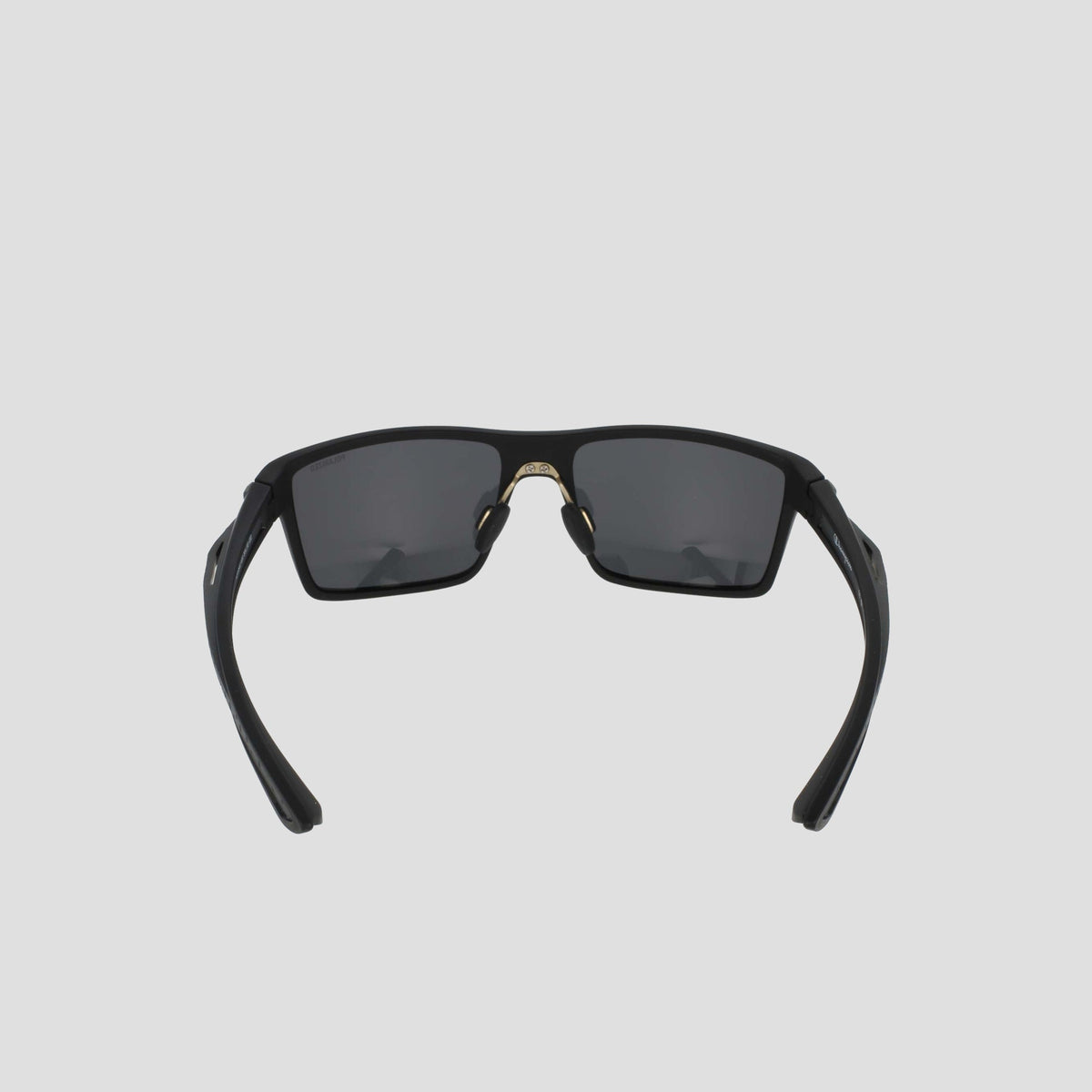 Men's Polarized Comfort Fit - Medium sunglasses by Champion, shown from the front against a light gray background. Featuring a lightweight black rectangular frame with dark lenses, the partially folded arms and visible nose pads highlight their comfortable design.